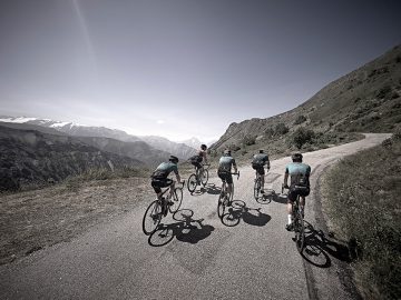 Cykelryttere på vej op ad bjerg.