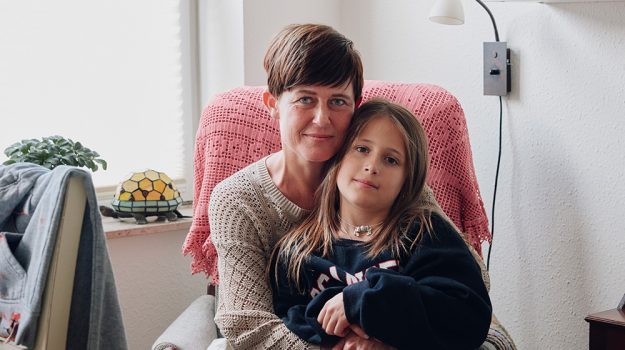 Mor og datter sidder sammen i lænestol