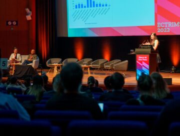 Billede af scenen til Sclerosekonference i Amsterdam, hvor der præsenteres et forskningsprojekt.