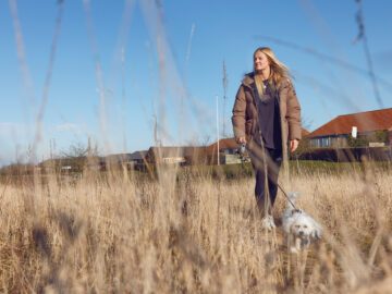 Sofie Bloch går ude på en mark med sin hund.