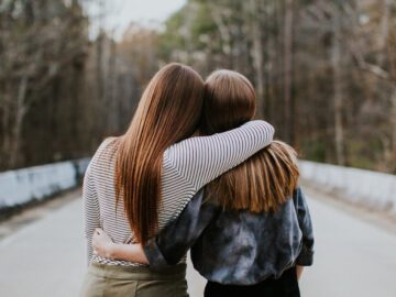 To unge kvinder lægger armene om hinanden