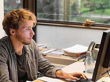 Ung mand sidder ved computer