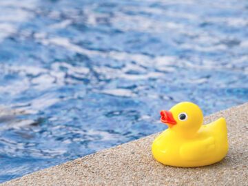 Gul badeand p&aring; poolkant